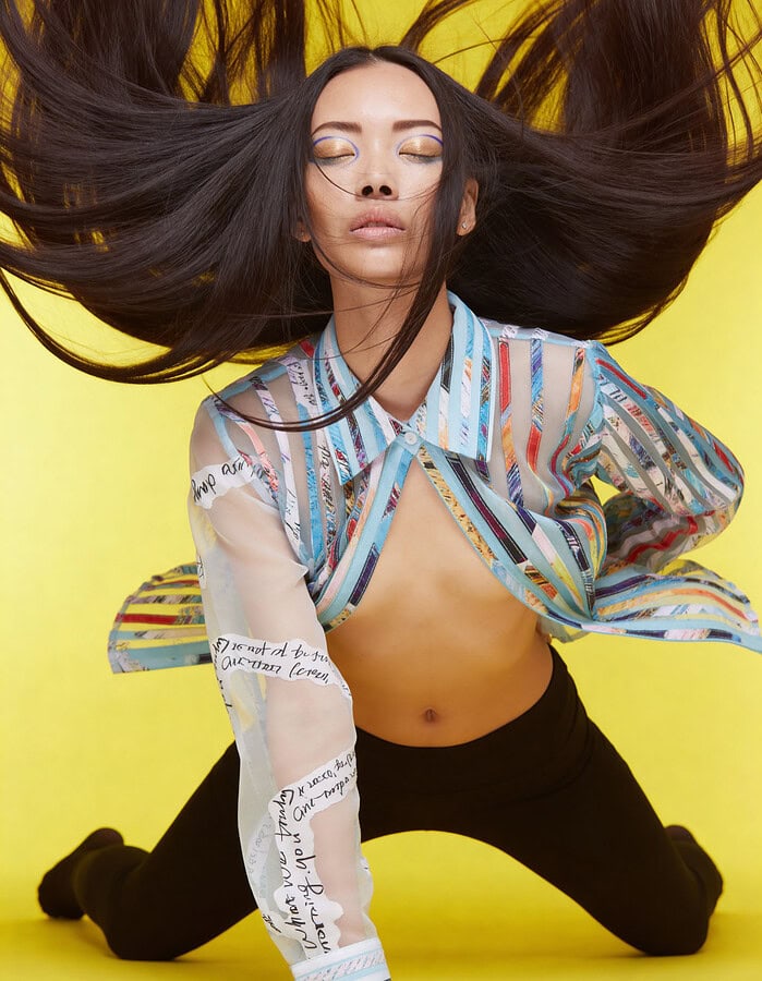 Fashion portrait of a woman with flowing hair against yellow background. photographer NYC