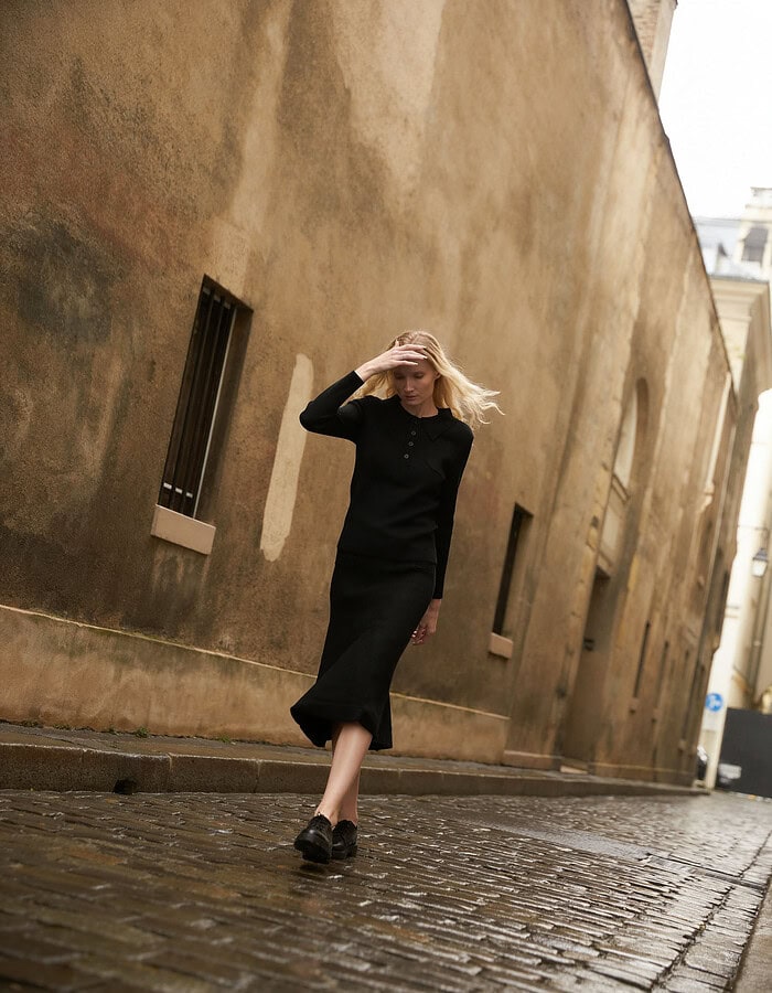 Fashionable woman walking on cobblestone street in urban setting. photographer NYC