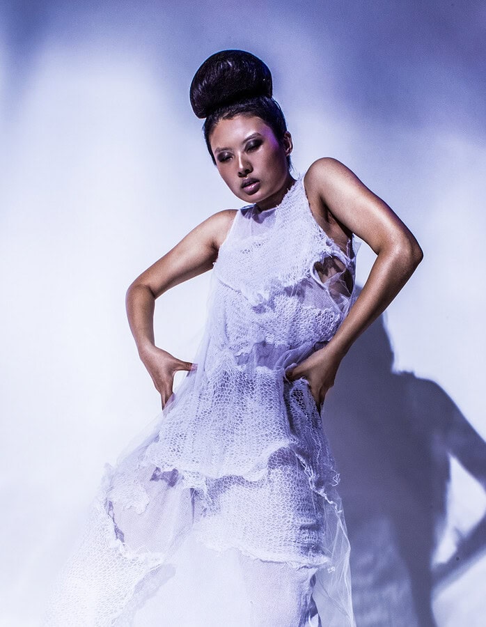 Three-panel movement study of a model posing in a layered white knit dress.