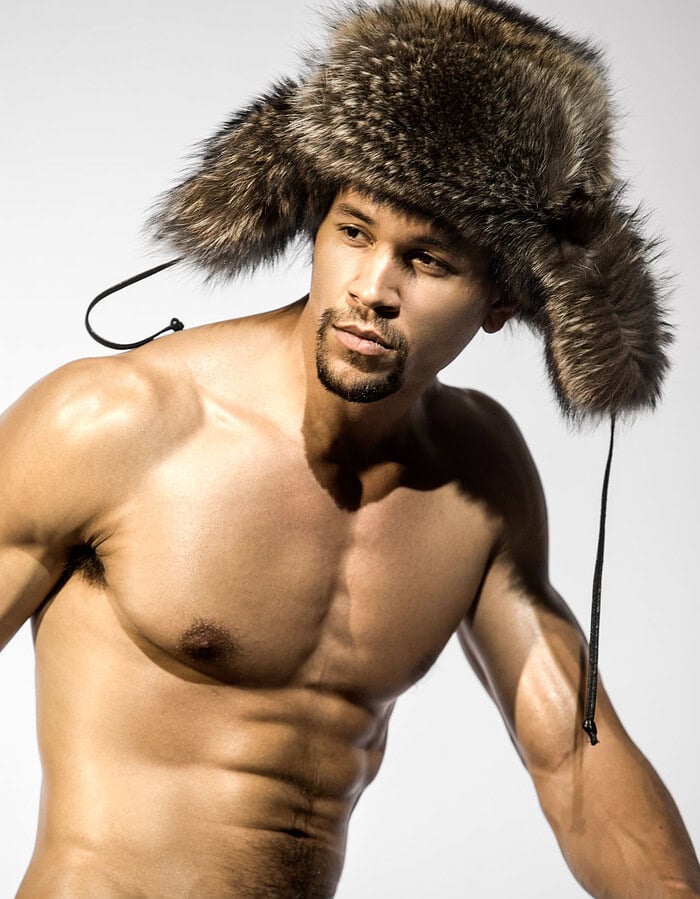 Male model wearing a large textured winter hat during a New York studio model test.